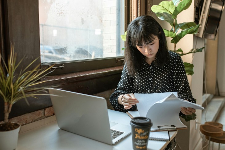 Lady with laptop reviewing documents in cafe